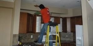 Technician Removing Water Damage Off Of Ceiling